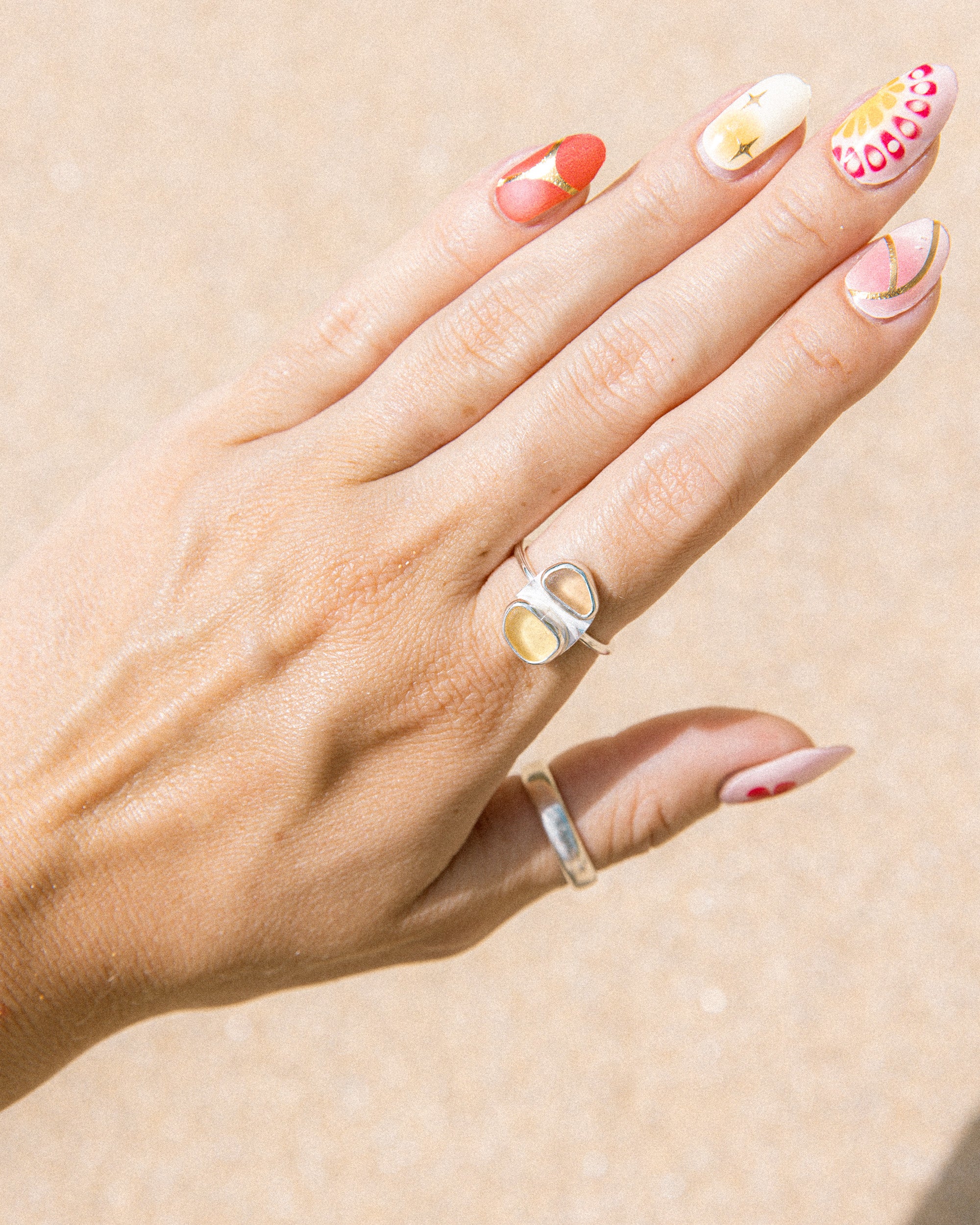 Green and amber sea glass ring worn on hand, handmade sterling silver, Broken Wave Jewellery Newquay
