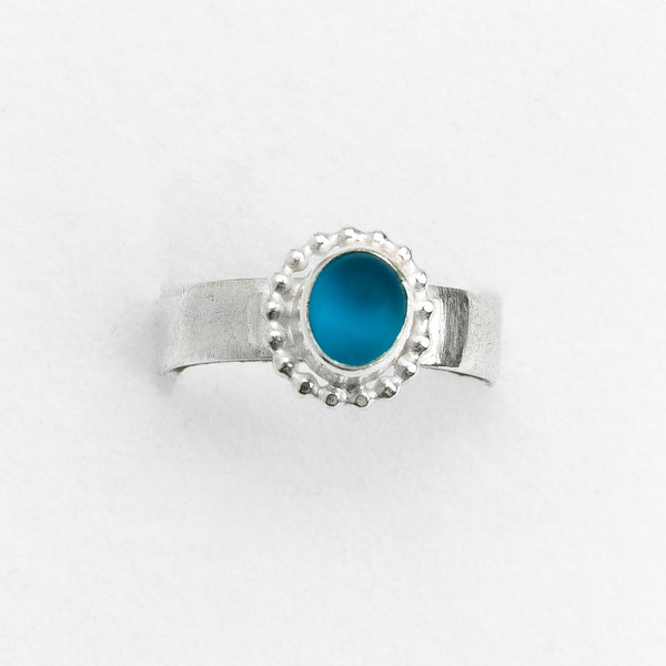 Silver ring with a blue stone on a white background