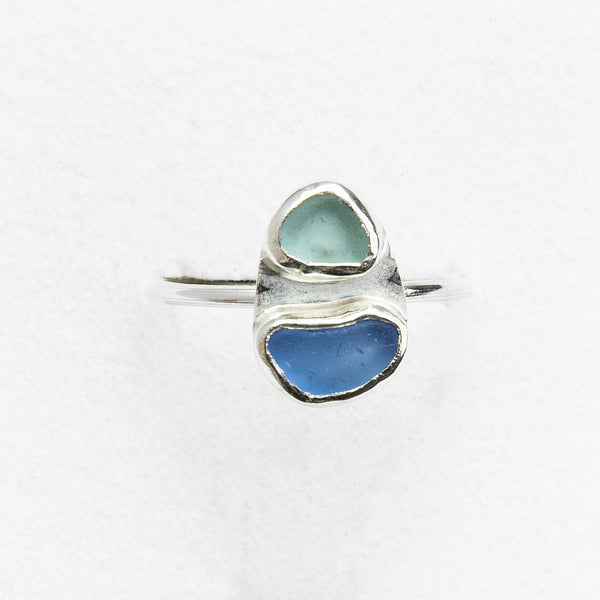 Silver ring with two heart-shaped blue stones on a white background