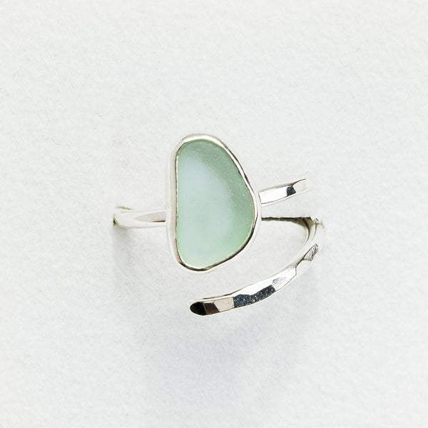 Silver ring with a light blue sea glass on a white background