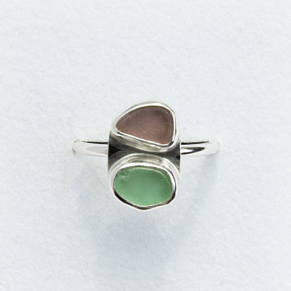 Silver ring with two colored stones on a light gray background