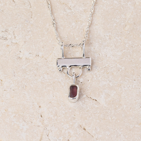 Deep purple sea glass hanging from a sterling silver bar on a fine chain, handmade in Cornwall