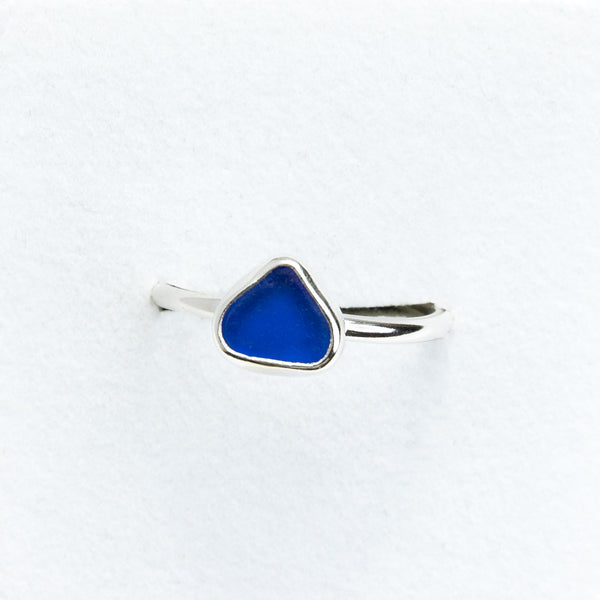 Silver ring with a blue teardrop-shaped stone on a white background