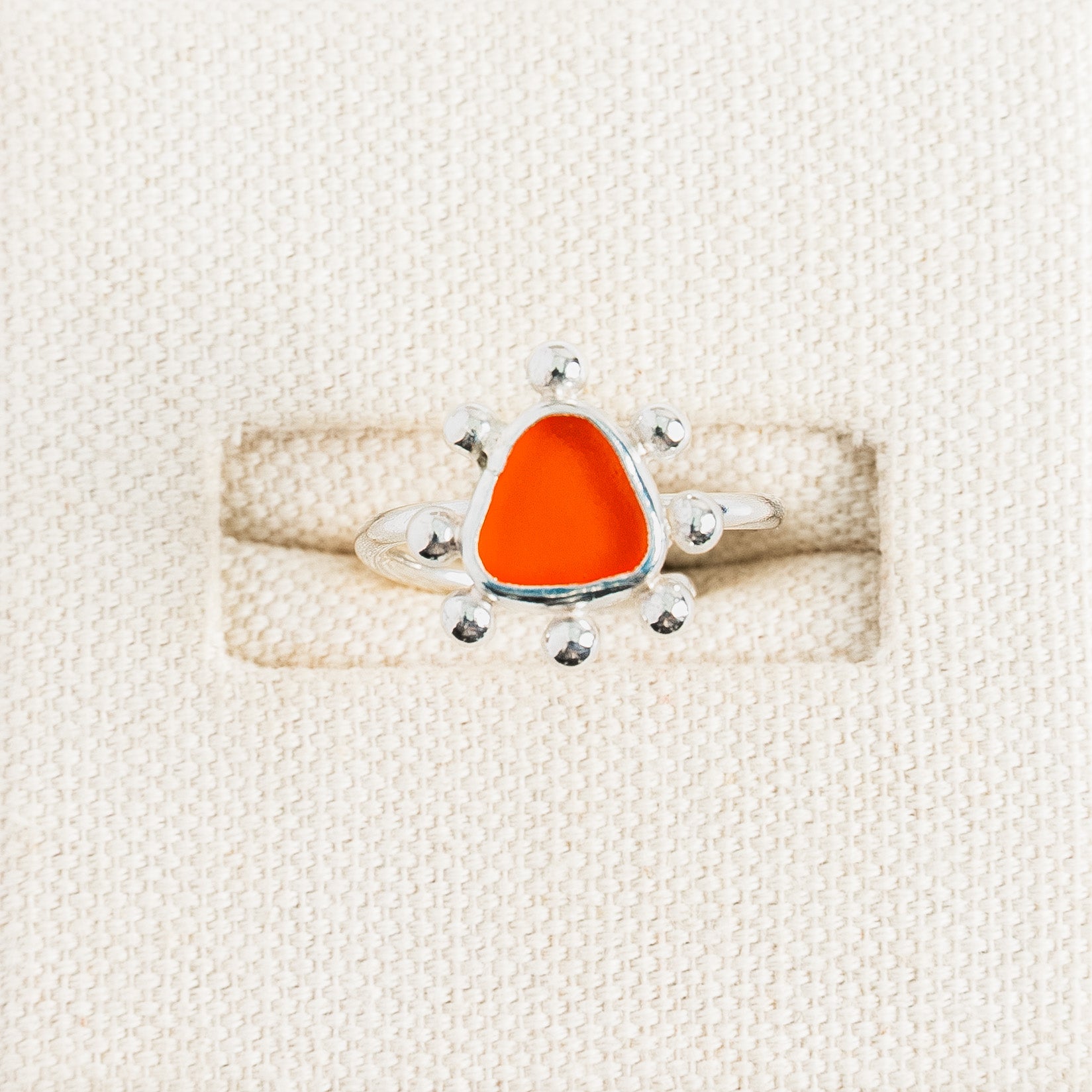 Rare orange sea glass ring with handmade sterling silver sunburst setting by Broken Wave Jewellery Cornwall
